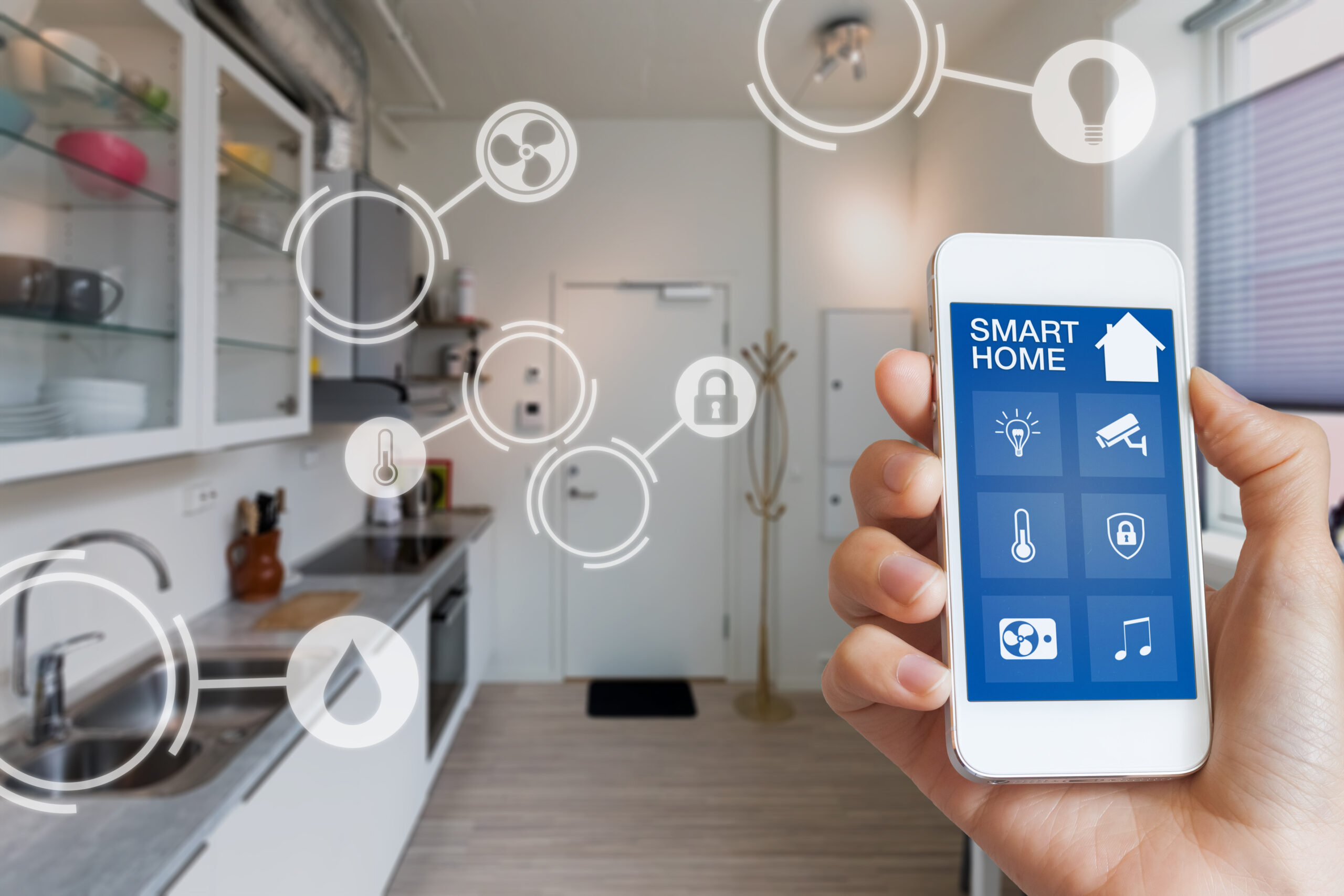 Mão segurando celular com aplicativo de smart home, que conecta diferentes dispositivos em uma casa utilizando IoT